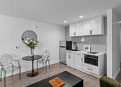 Thumbnail 2 of 11 - a kitchen with white cabinets and a table with chairs